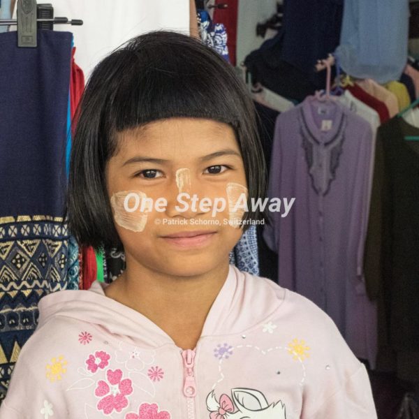 Myanmar - Yangon / Market Girl, used cloth in the background, Marktmädchen, gebrauchtee Kleider im Hintergrund