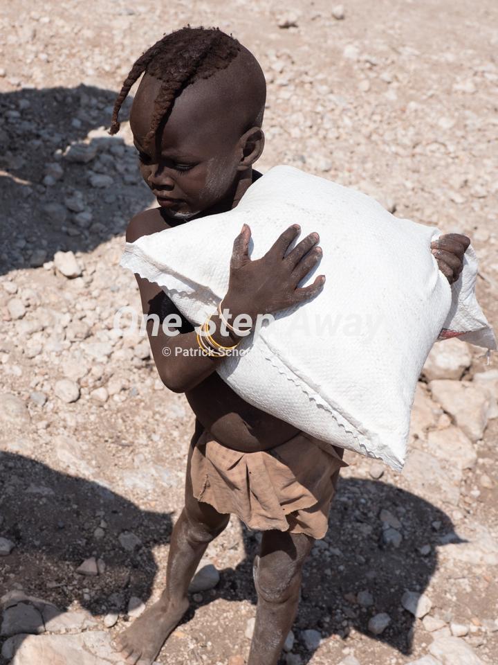 Namibia - Camp Aussicht / Visit Himba village little boy with rice pack, Besuch Himba Dorf kleiner Knabe mit Reissack